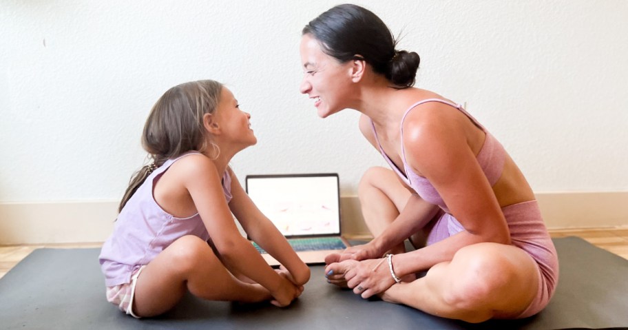 woman and girl stretching in front of a laptop