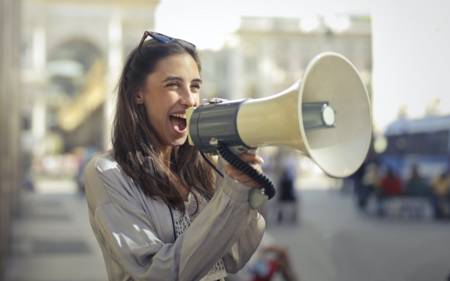 woman shouting in mega phone, perhaps applying for the Shout It Out scholarship, one of the random and weird scholarships available to students