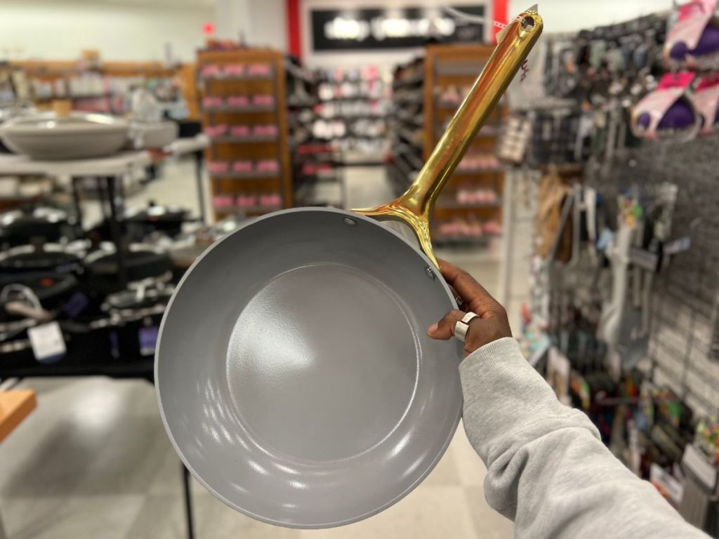 A hand holding a Caraway Pan 