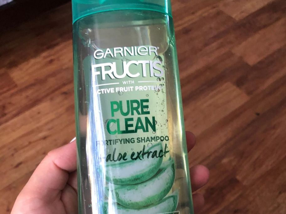 hand holding Garnier Hair Care Fructis Pure Clean Shampoo 12.5oz Bottle