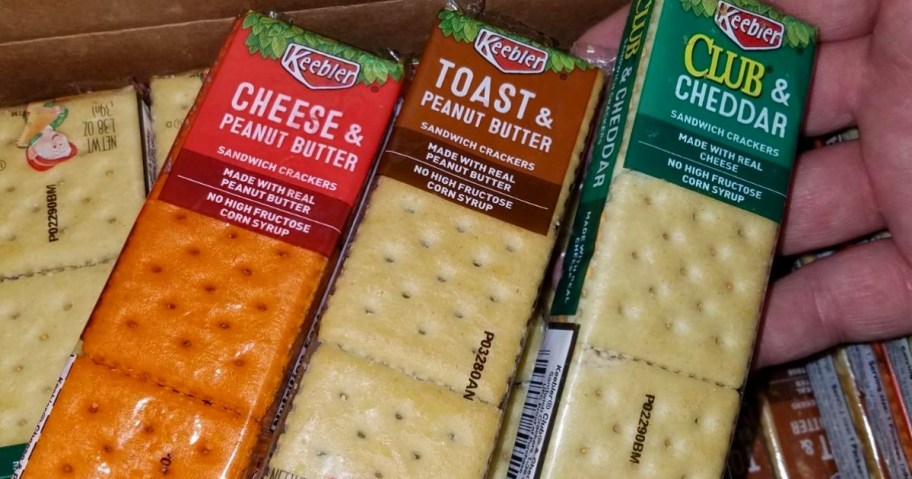 hand pulling a pack of Keebler crackers out of a box full of more crackers