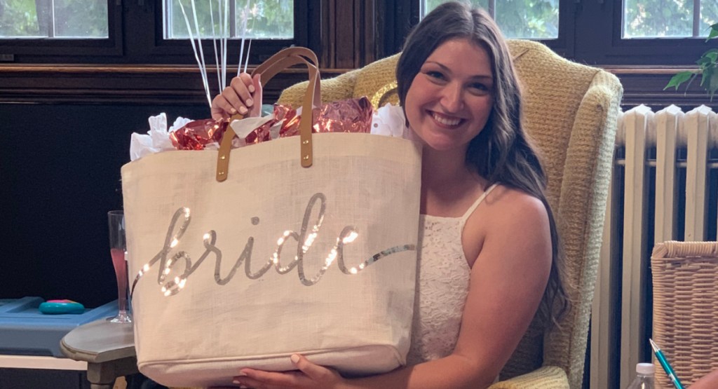 Bride holding up a bride bag at her bridal shower