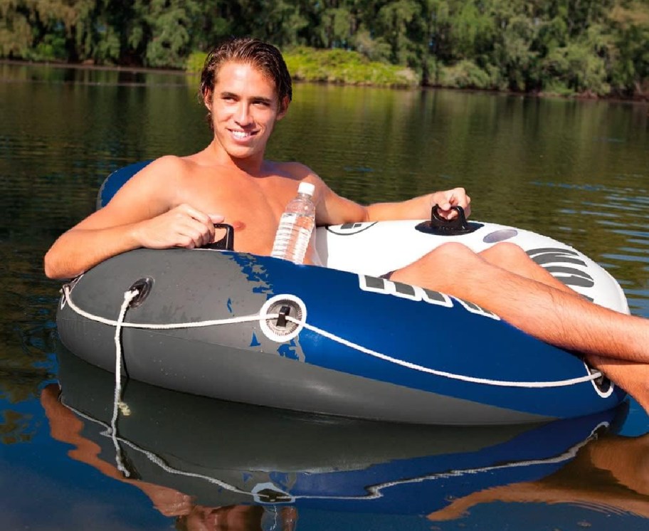 A man sitting in an round float floating in a river