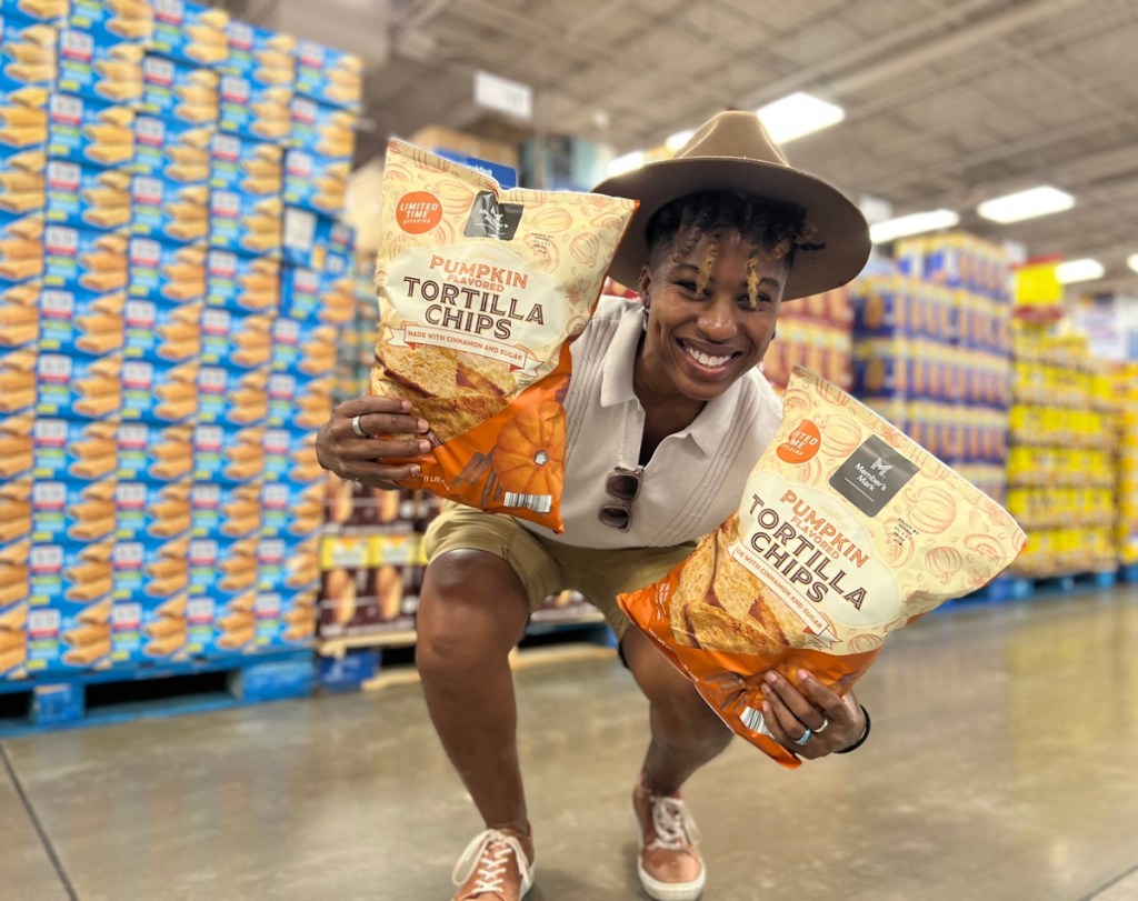 woman holding Member's Mark Pumpkin Tortilla Chips at Sam's