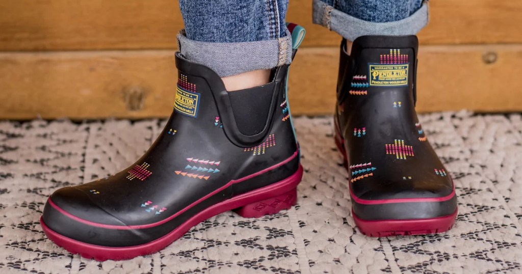 woman wearing black geometric print short rain boots