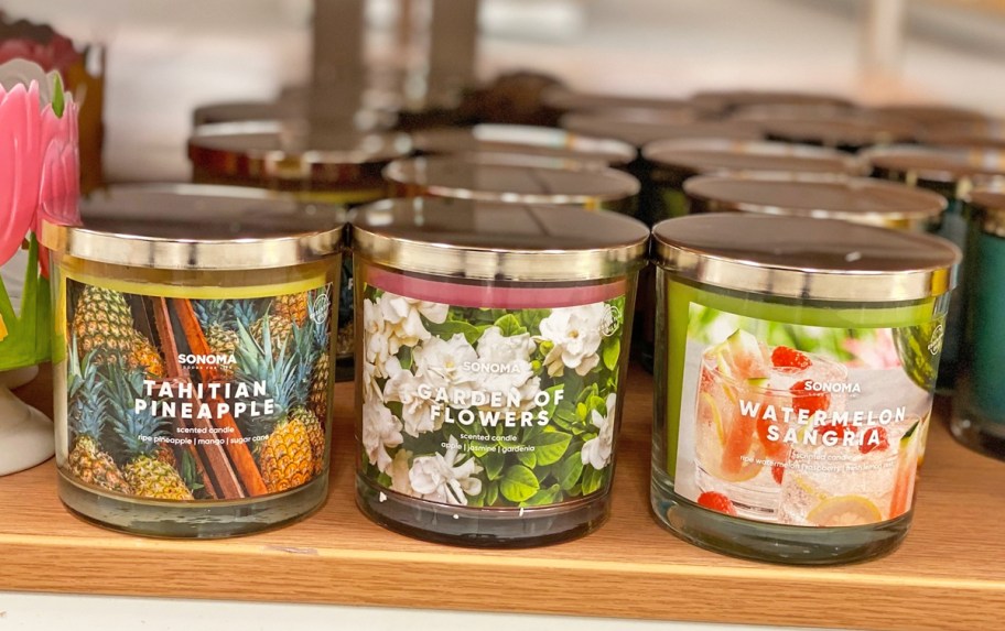 row of sonoma 3-wick candles on wood shelf