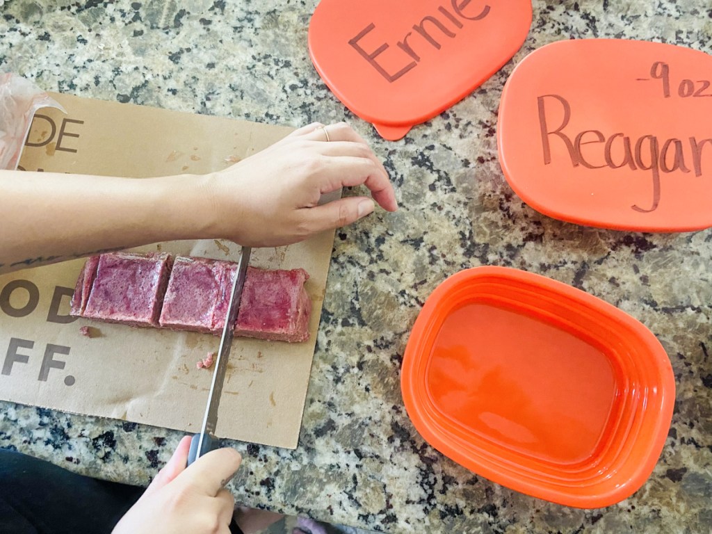 cutting up portions of we feed raw dog food