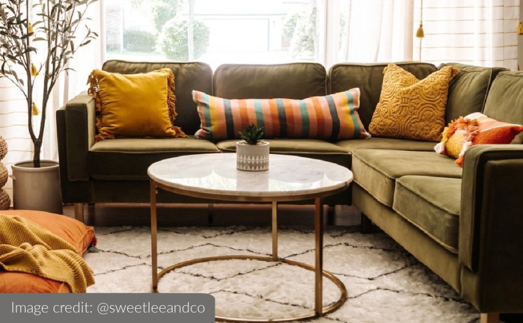 dark green sectional sofa in boho living room with colorful throw pillows