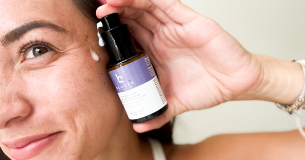 woman putting serum on face