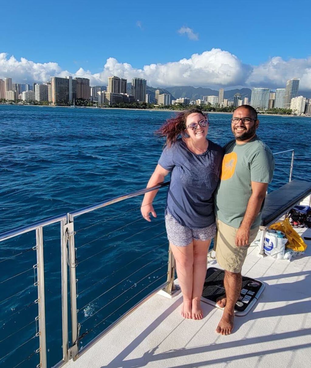 man and woman standing on boat in water