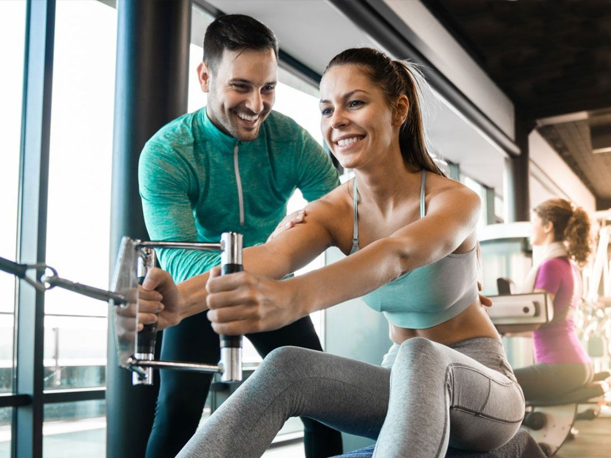 woman working with personal trainer at the gym