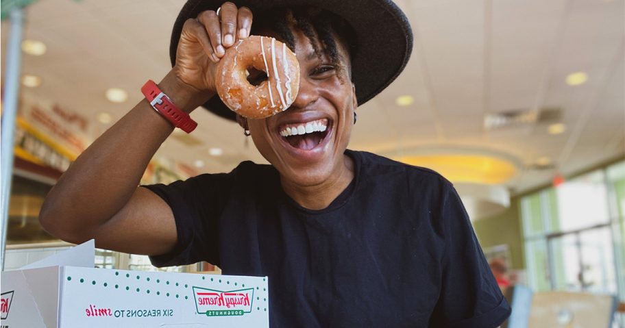 woman holding krispy kreme pumpkin spice donut