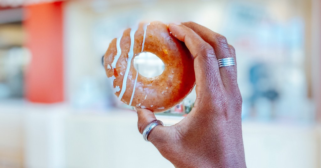 krispy kreme pumpkin spice doughnut in hand