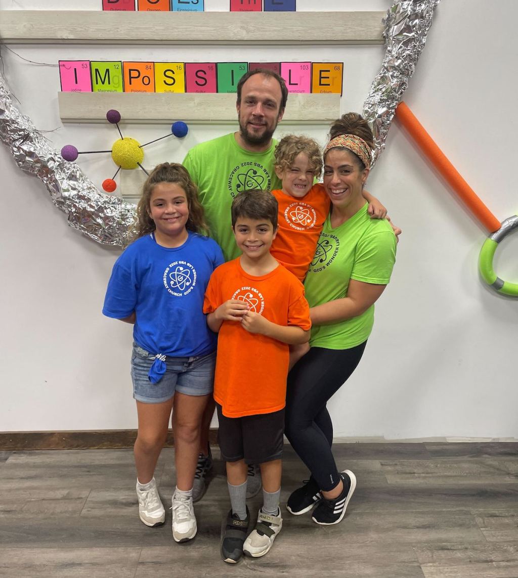 family wearing colorful shirts in science museum