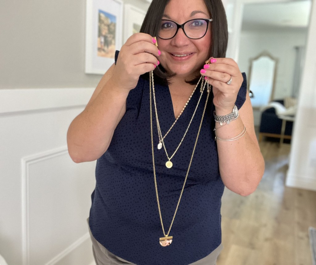 Woman holding a magnetic necklace clasp for layering necklaces