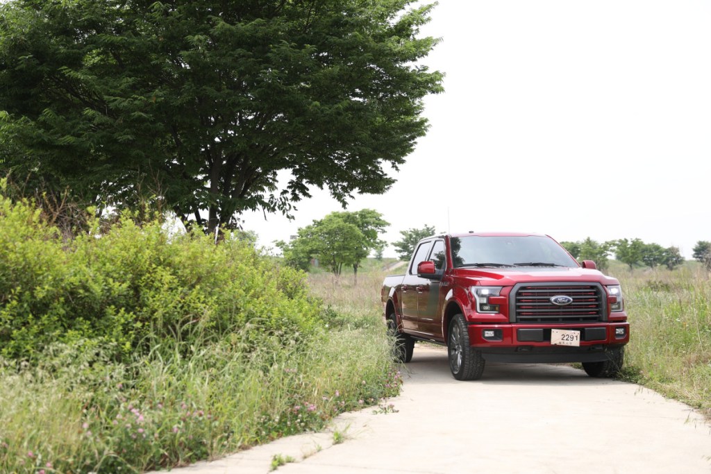 a red pick up truck driving in the country