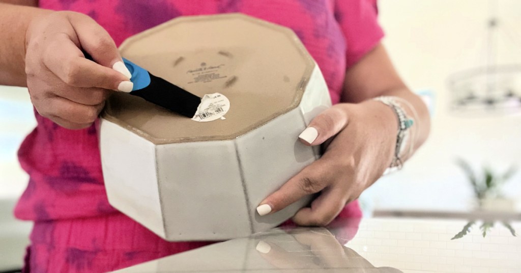 scraping a price tag off a bowl using thumb scraper