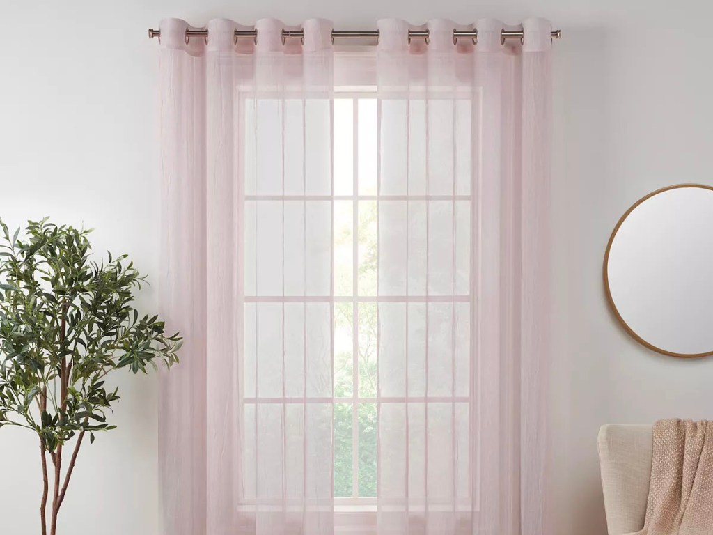 sheer pink window curtain hanging at window