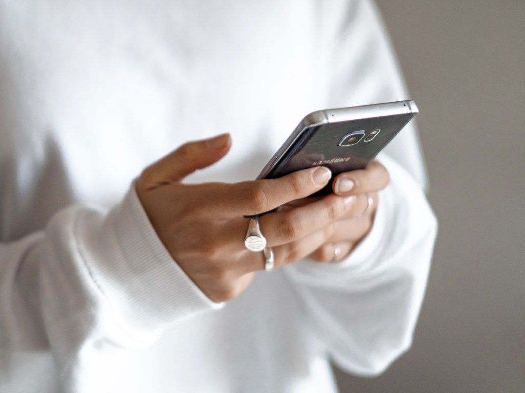 woman holding black phone