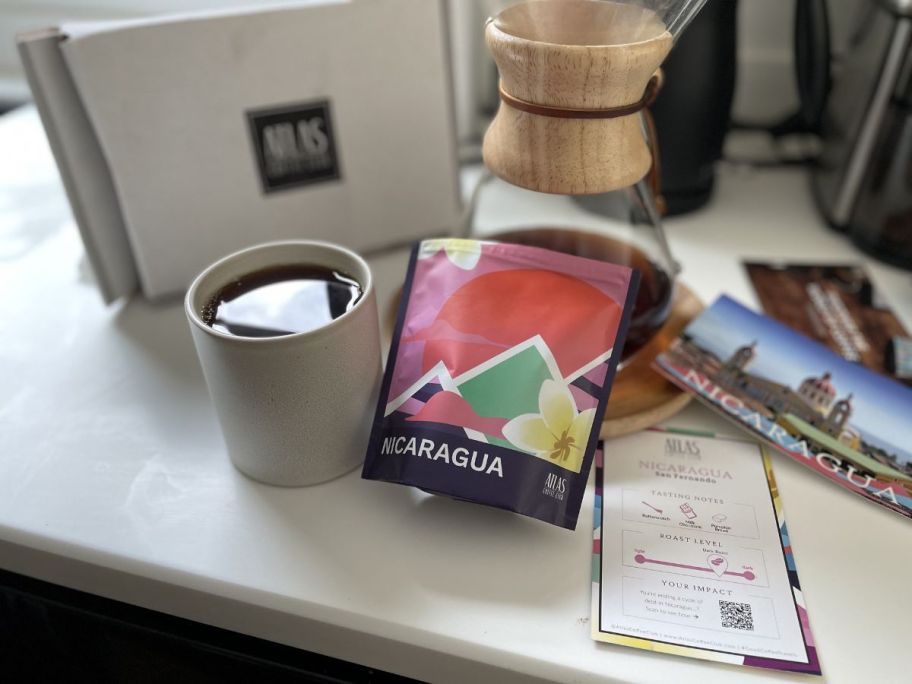 bag of atlas coffee next to coffee mug