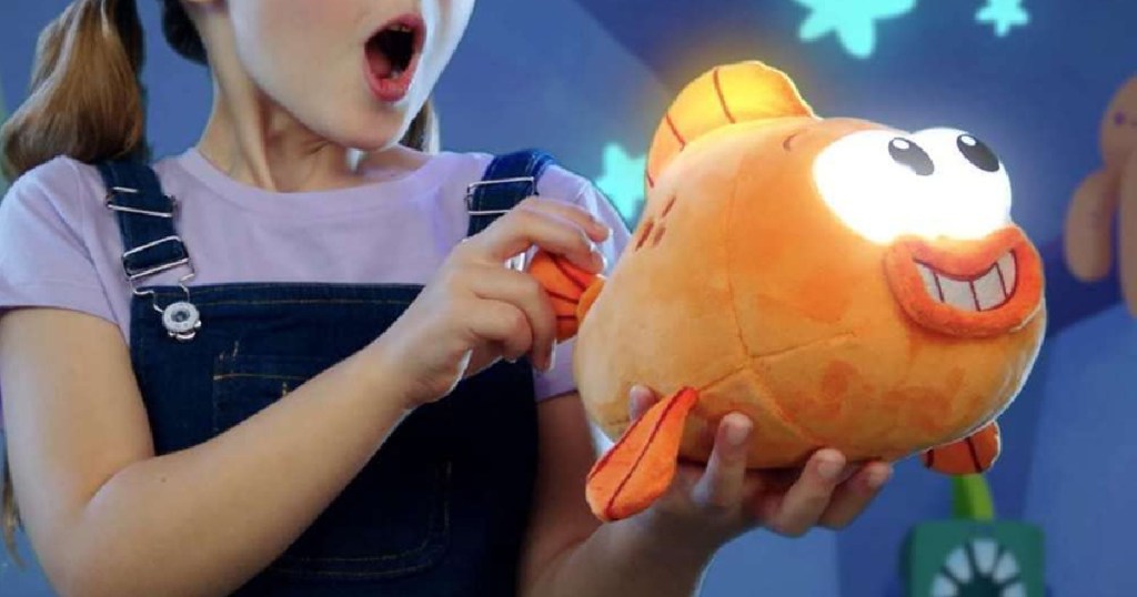 girl holding shark plush flashlight