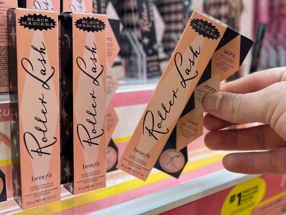 Hand grabbing a benefit roller lash mascara from the shelf