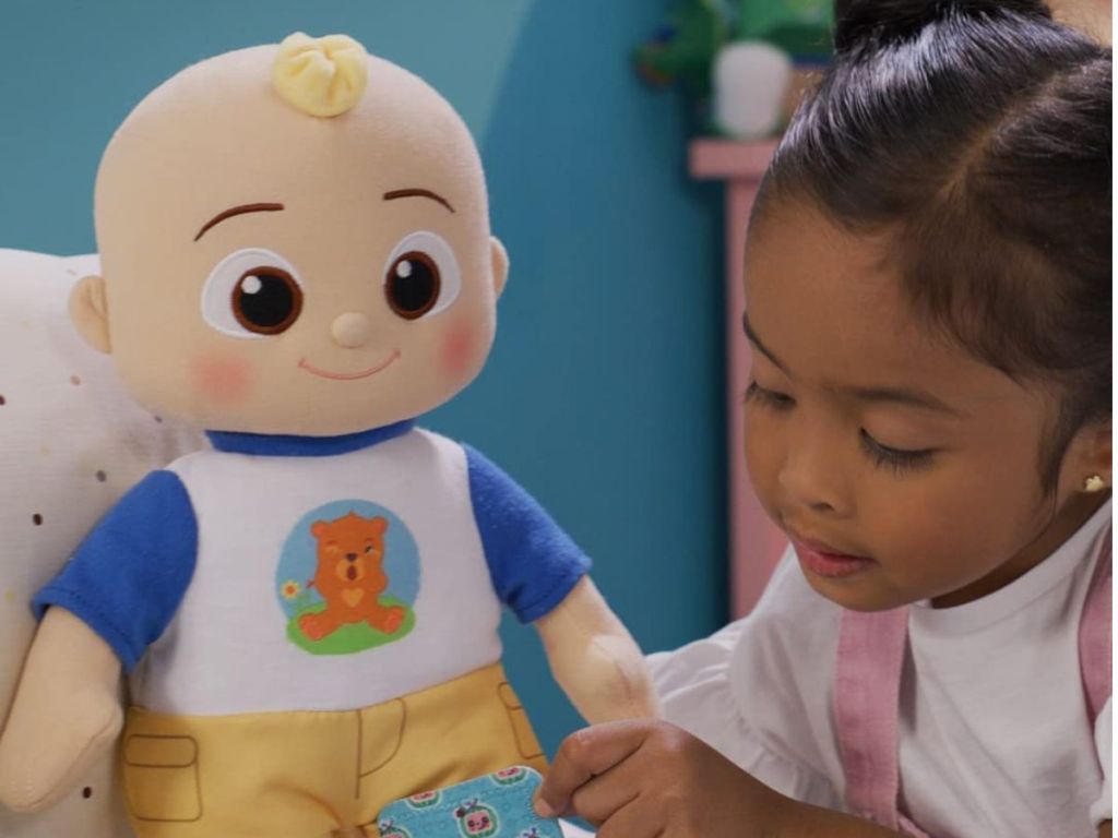 little girl playing with CoComelon Boo Boo JJ Deluxe Feature Plush 