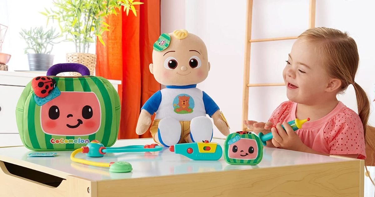 little girl playing with CoComelon Boo Boo JJ set with plush doll and accessories