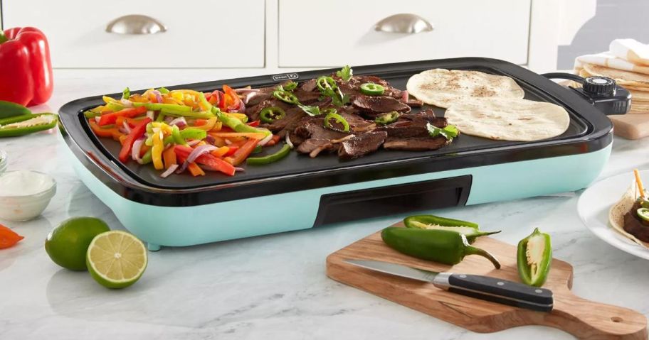 Dash Griddle cooking food for fajitas on a kitchen counter