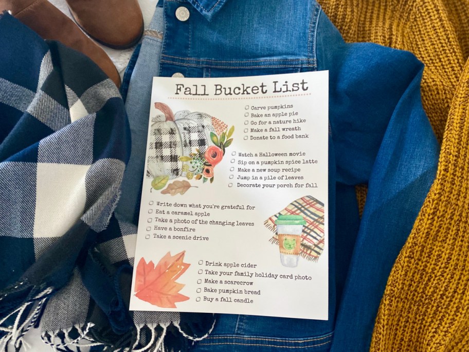 Fall bucket list on a stack of fall clothing 