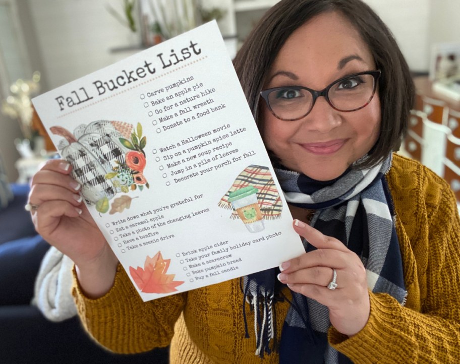 woman holding up a fall bucket list