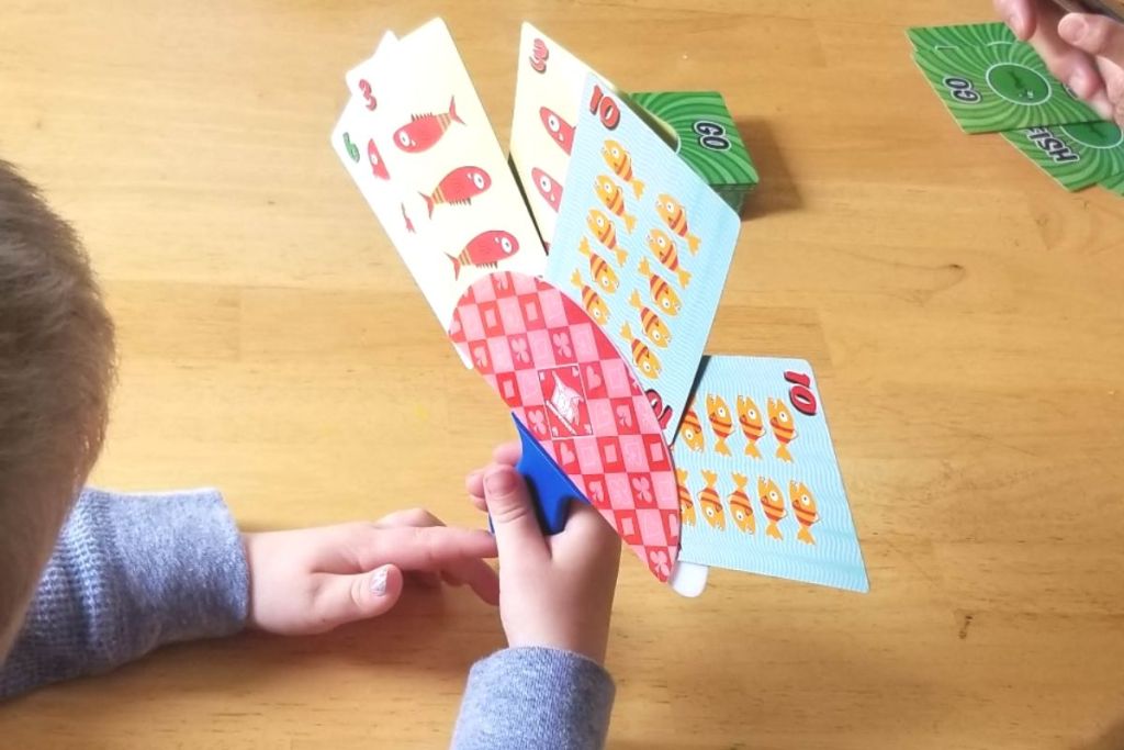 Little boy playing Go Fish card game using a Gamewright - The Original Little Hands - Playing Card Holder