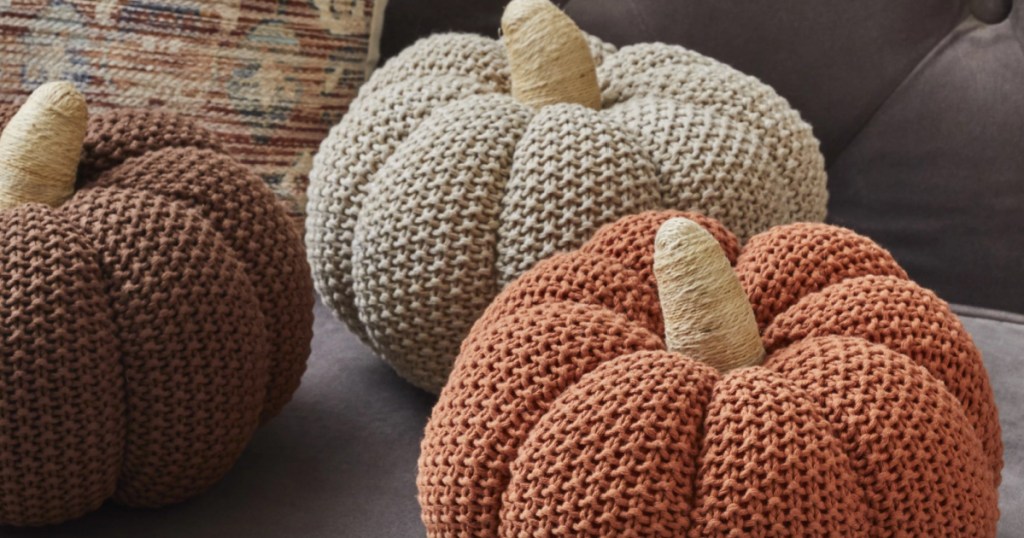3 different colored knit pumpkins on table