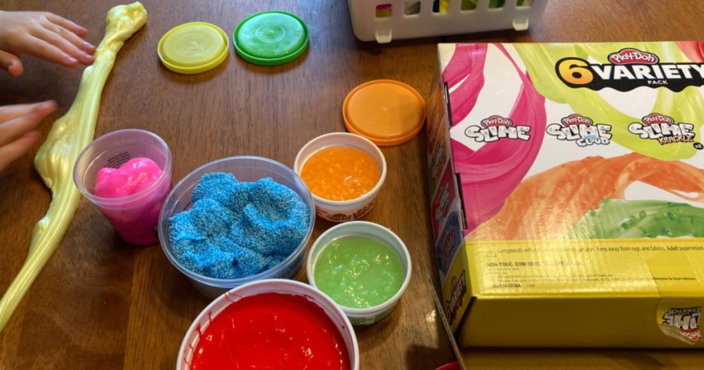 child playing with Play-Doh slime at table