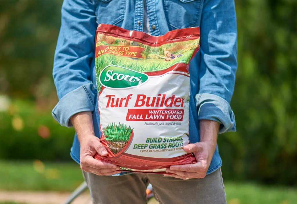 person holding a bag of Scotts Turf Builder