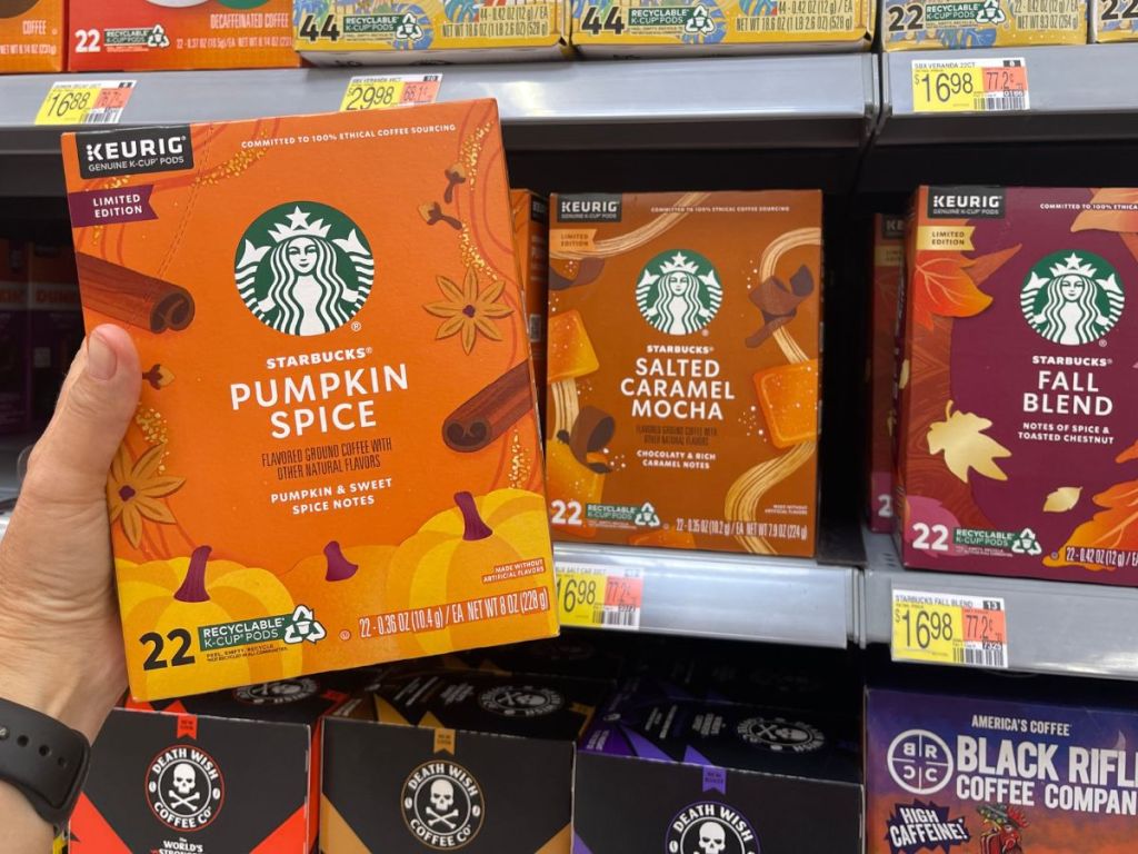 A hand holding pumpkin spice coffee