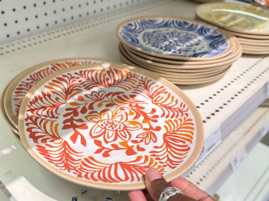 Hand touching a Threshold salad plate on the shelf at Target