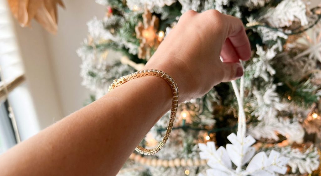 hand putting ornament on tree