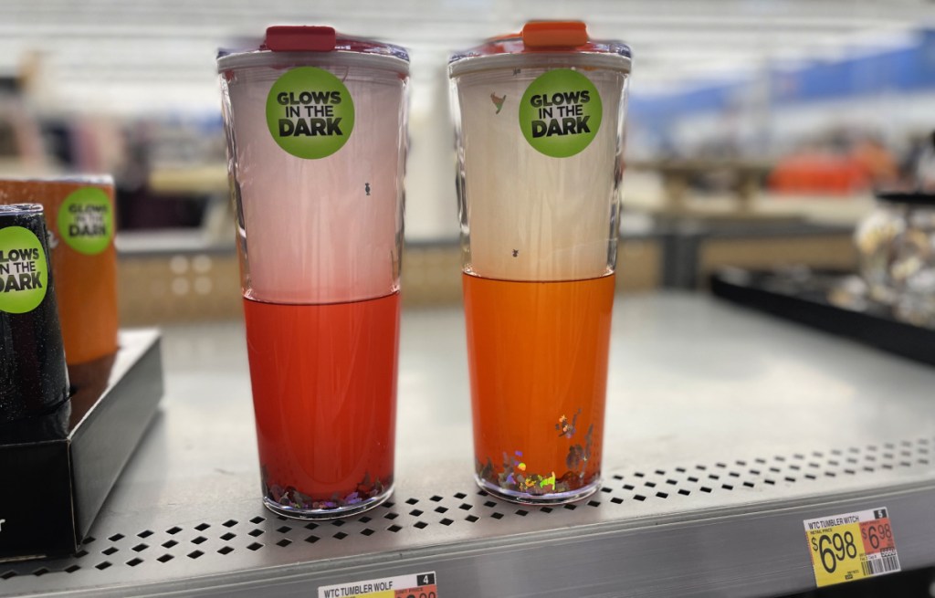 two glow in the dark walmart halloween tumblers sitting on a store shelf