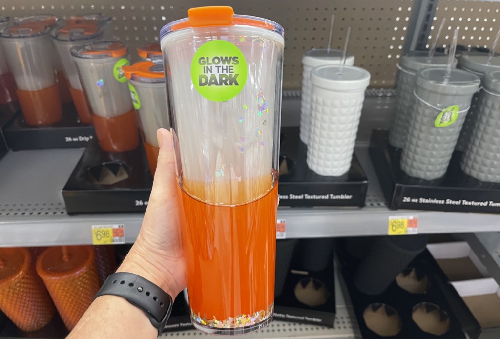 glow in the dark walmart halloween tumbler held in hand in front of a store shelf