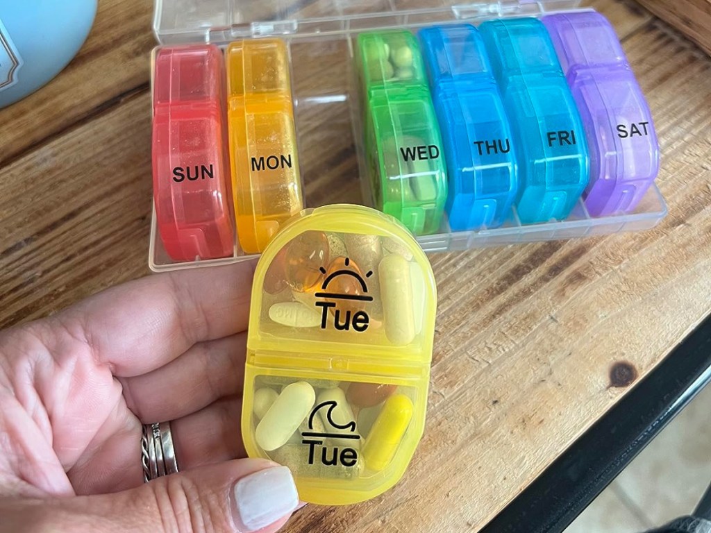 hand holding pill encase with colorful case on the background