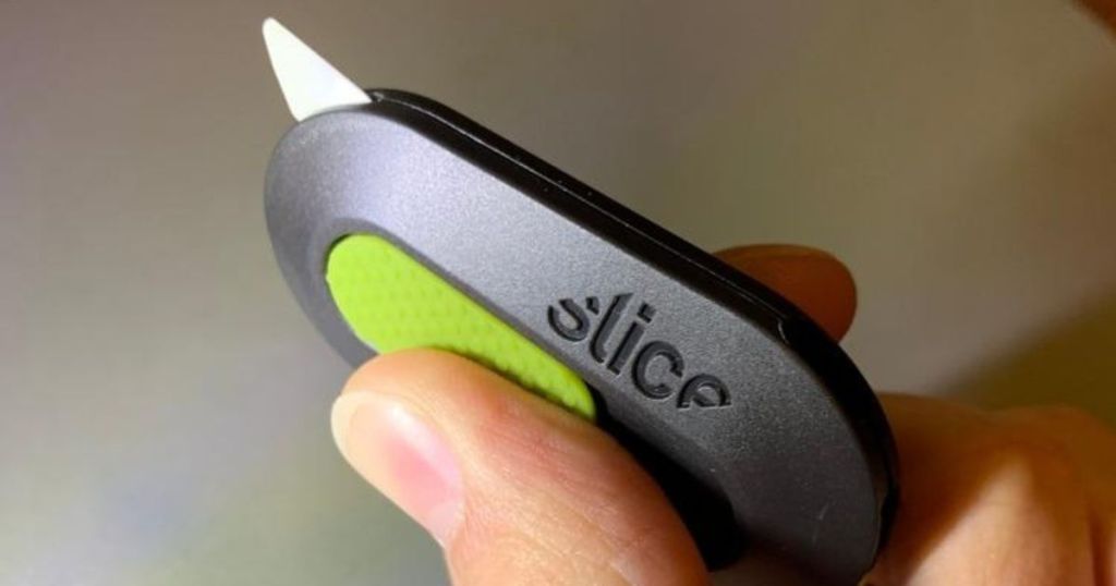 slice box cutter in someone's hand