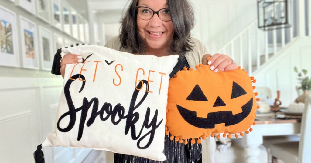 woman holding halloween pillows