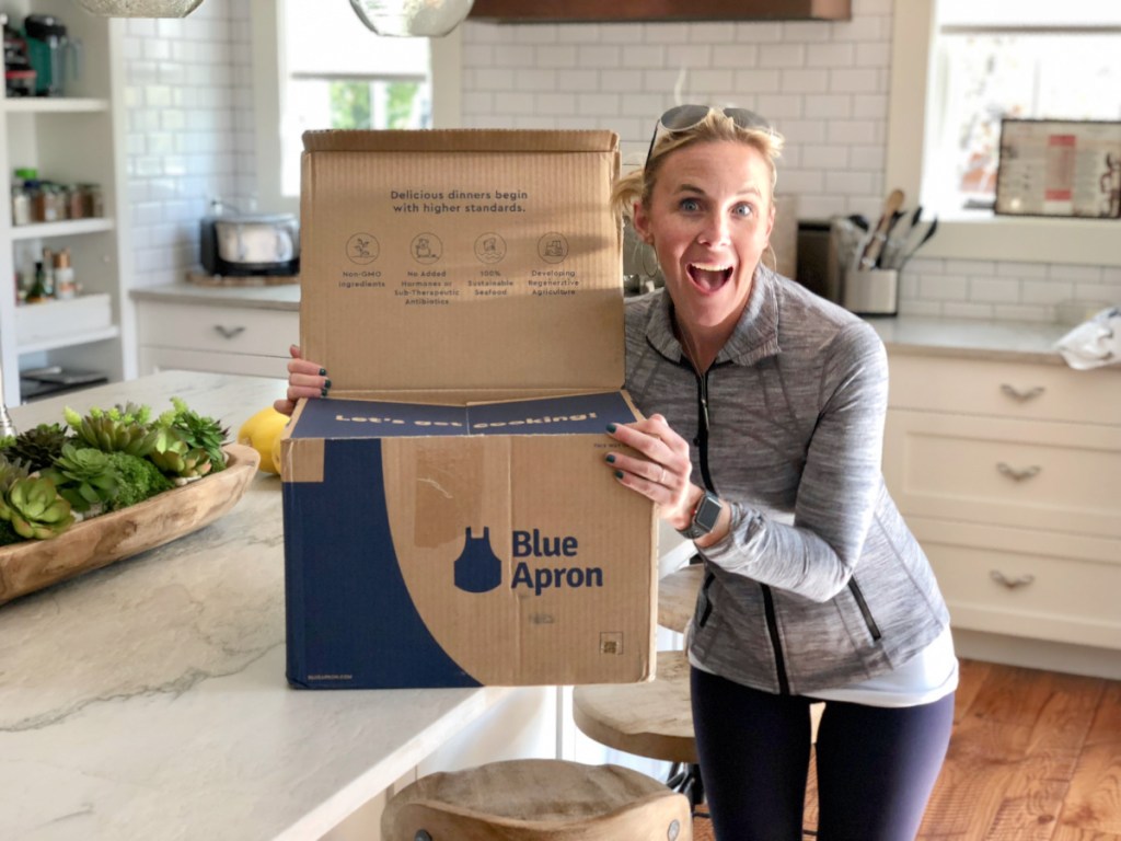 Woman holding blue apron boxes