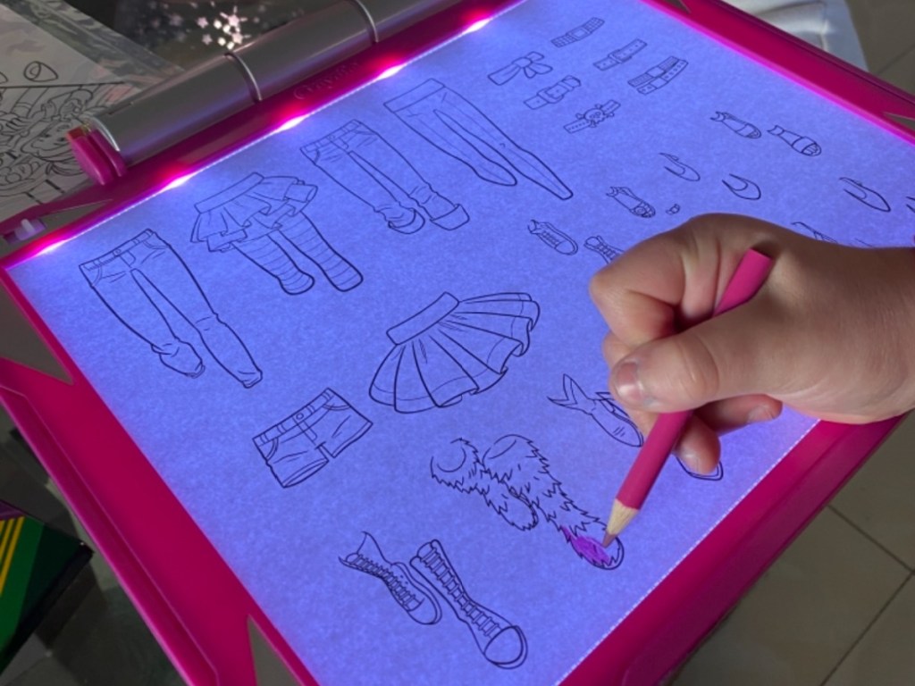 person using an illuminated crayola light up tracing pad