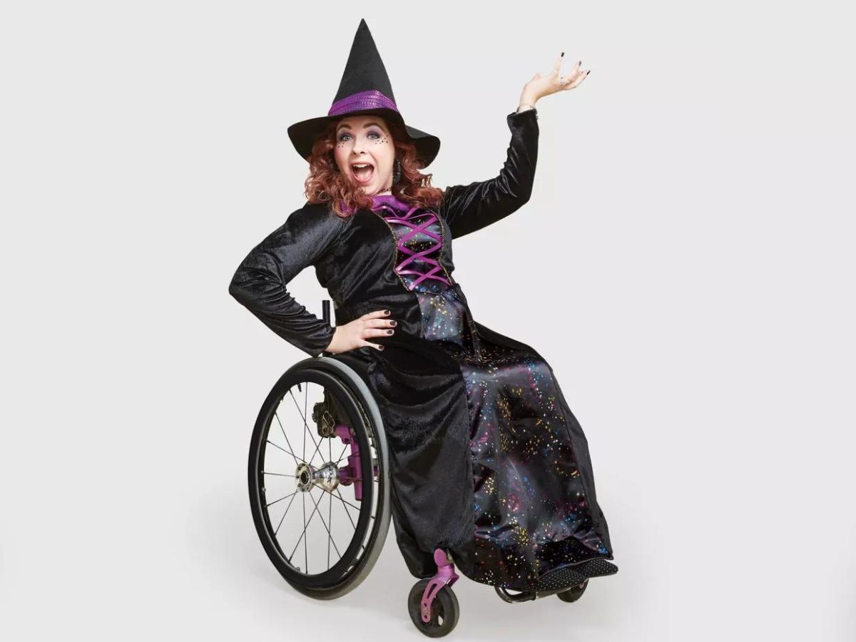 girl wearing witch costume sitting in wheelchair