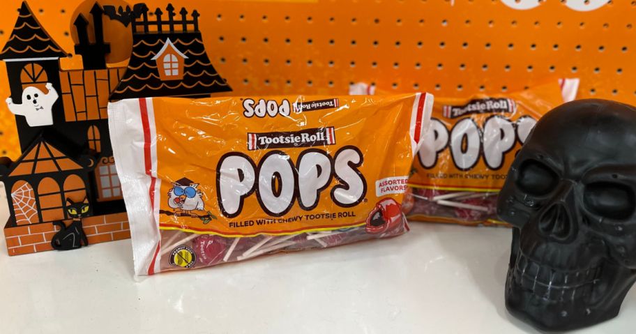 orange bag of lollipops in front of orange background