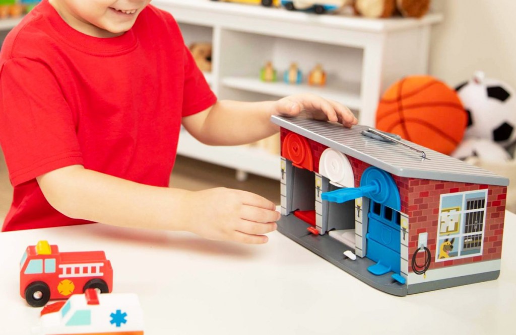 boy playing with Melissa & Doug Keys & Cars Rescue Garage set