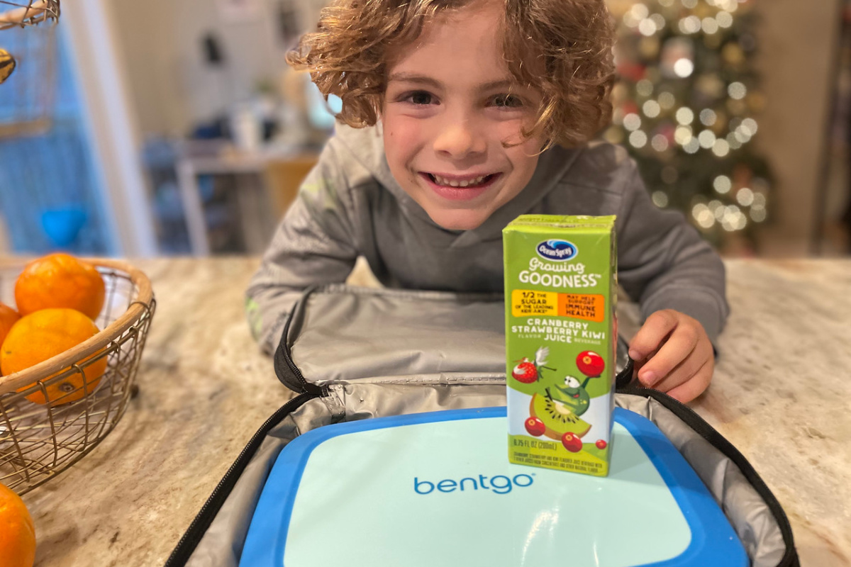 boy with a Ocean Spray Growing Goodness Juice Box on top of a blue bentgo box