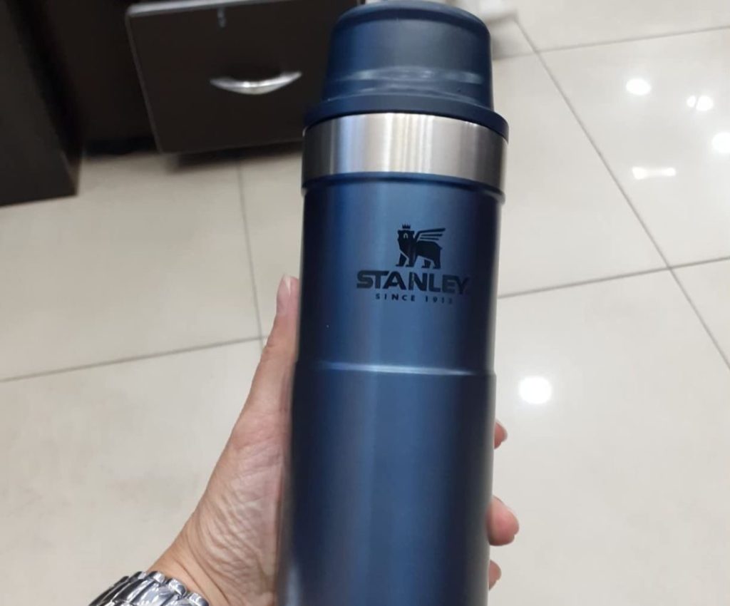 Hand holding aq blue Stanley Tumbler